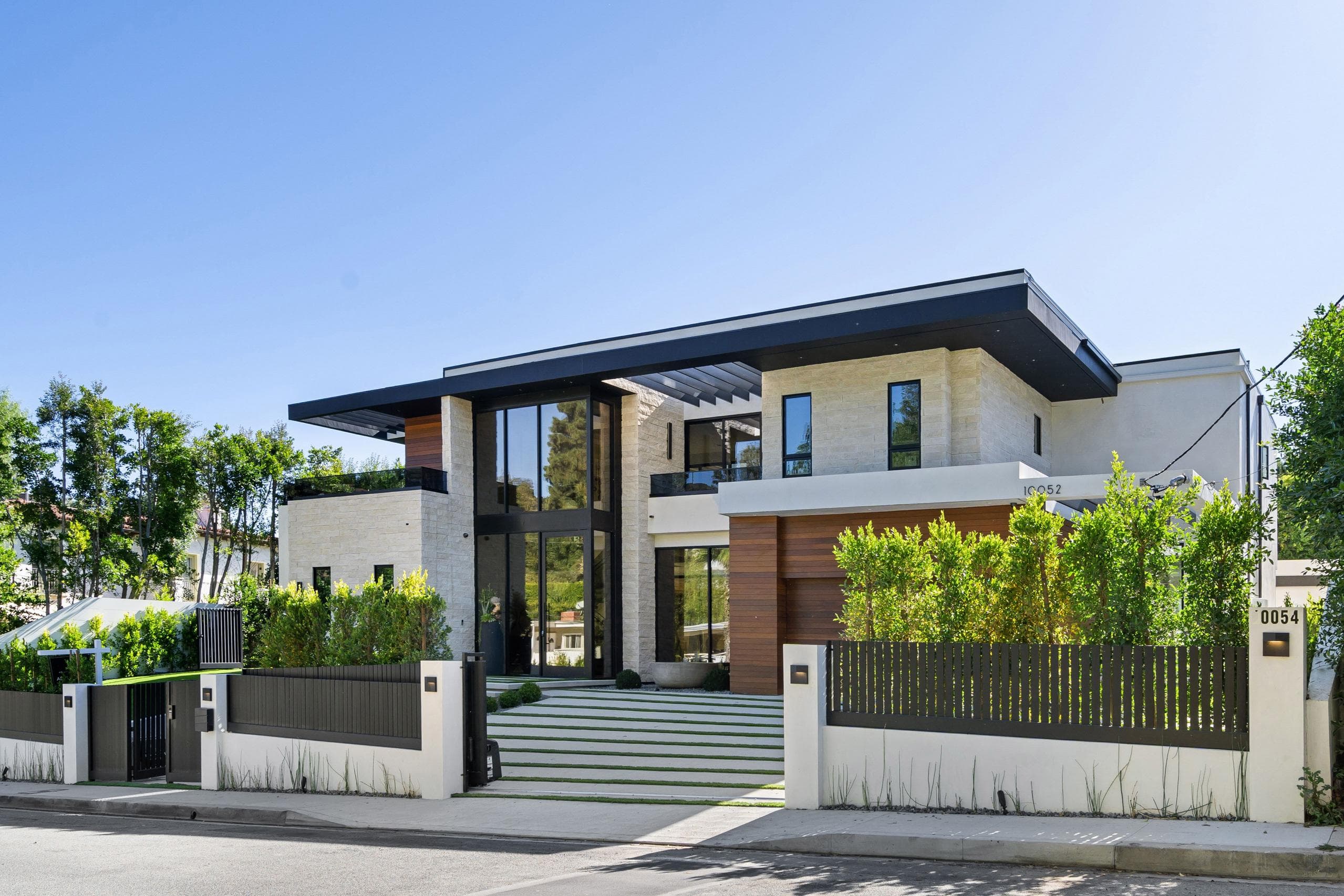 Modern luxury home with a landscaped garden at dusk — the kind of income property we source and operate on your behalf