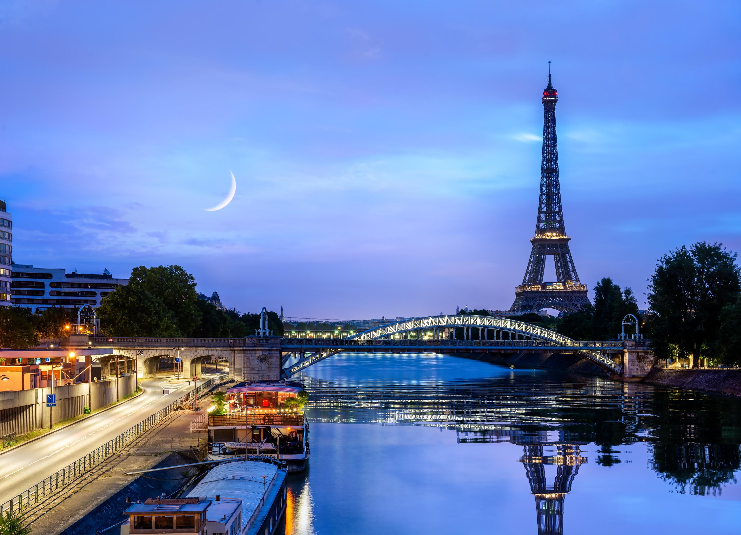 The Eiffel Tower in Paris with the moon rising behind it