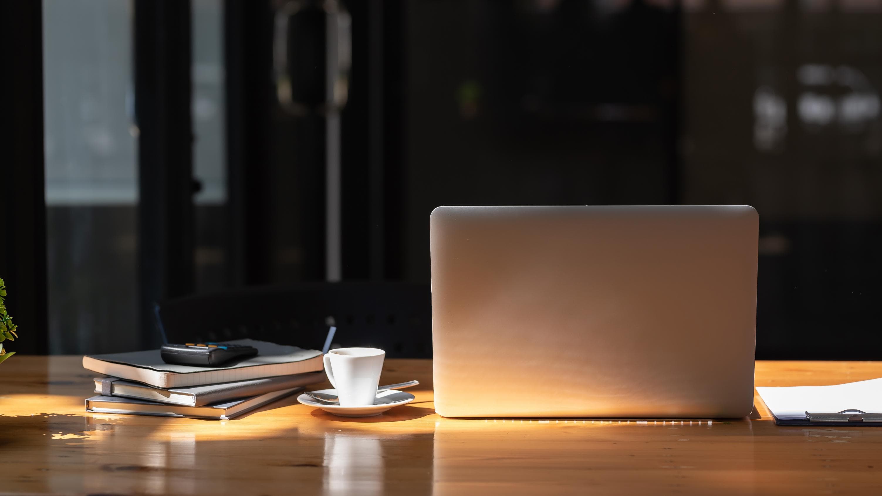 A focused work desk with a laptop, documents, and a calculator — where investor goals turn into a plan